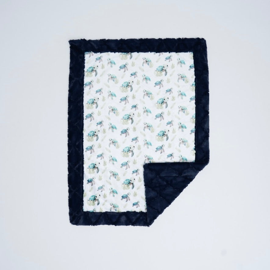 Baby blanket with animal pattern and navy border on a white background