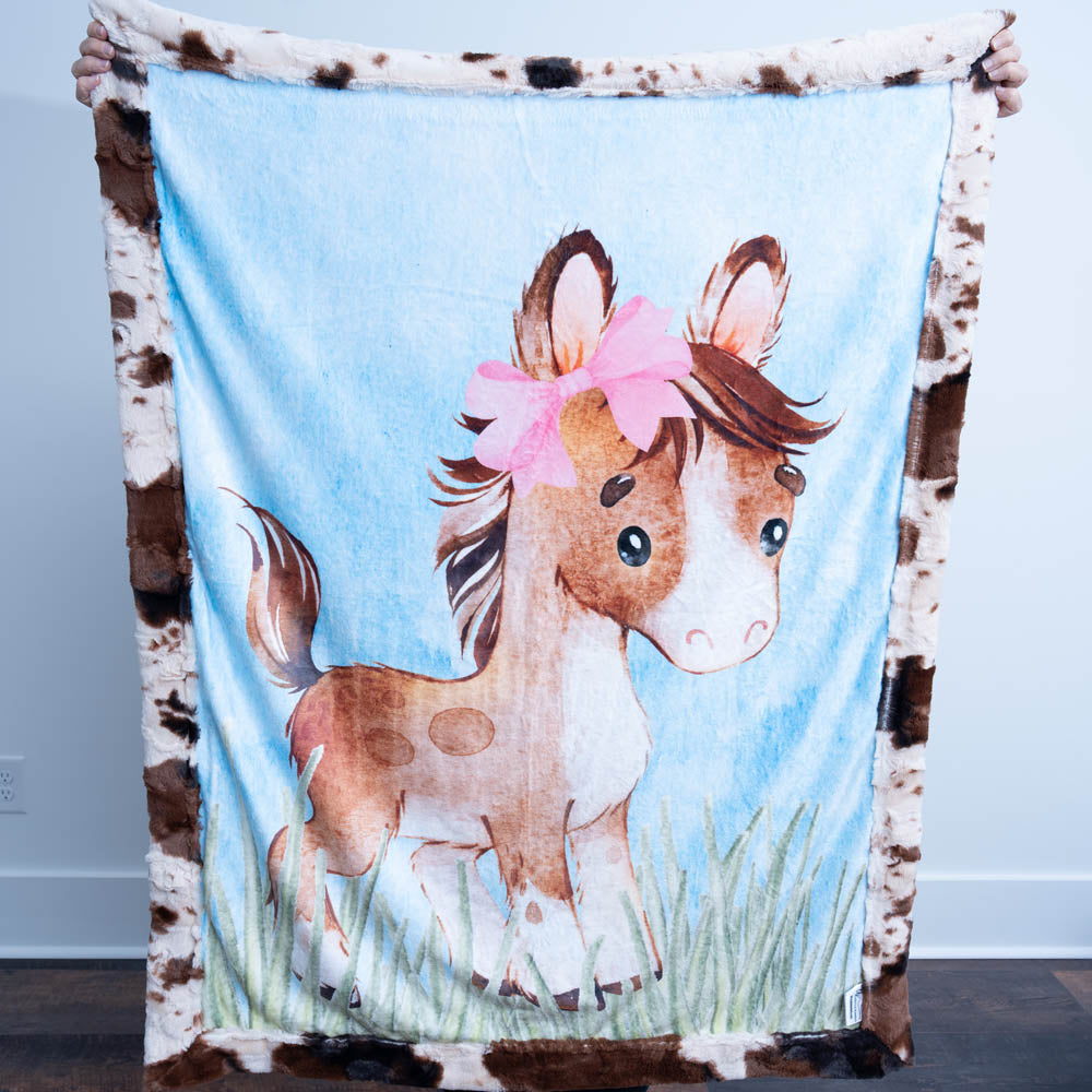 Blanket with a horse design and cowhide border