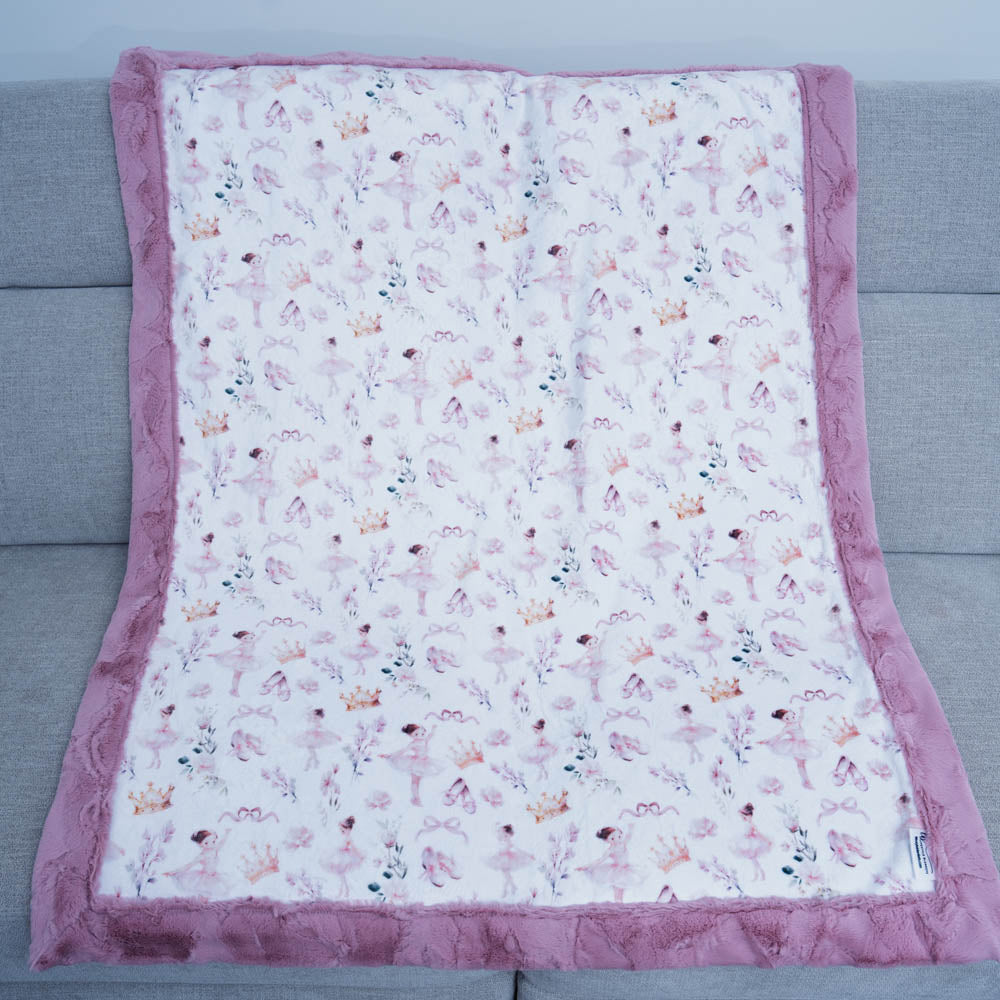 Floral patterned blanket with pink border on a gray couch