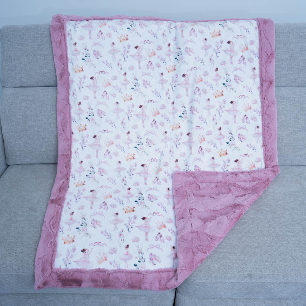 Floral patterned blanket with pink border on a gray couch