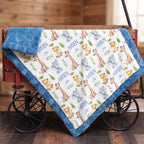 A plush baby blanket with a blue border and an all-over safari animal print featuring giraffes, lions, elephants, and the name 'Harden John' in blue script, draped over a rustic red wagon.