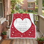 A red and white personalized blanket with a large white heart and 'I'm Hugging You With This Blanket! Love You, Brittany' text, draped over a wooden porch swing on a brick porch.