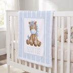 A personalized baby blanket draped over a white crib, featuring a watercolor illustration of a brown horse with a blue mane and the name 'SCOTTIE' printed below.