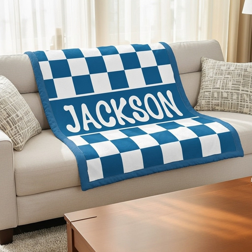 Blue and white checkered blanket with 'JACKSON' printed on a beige couch.