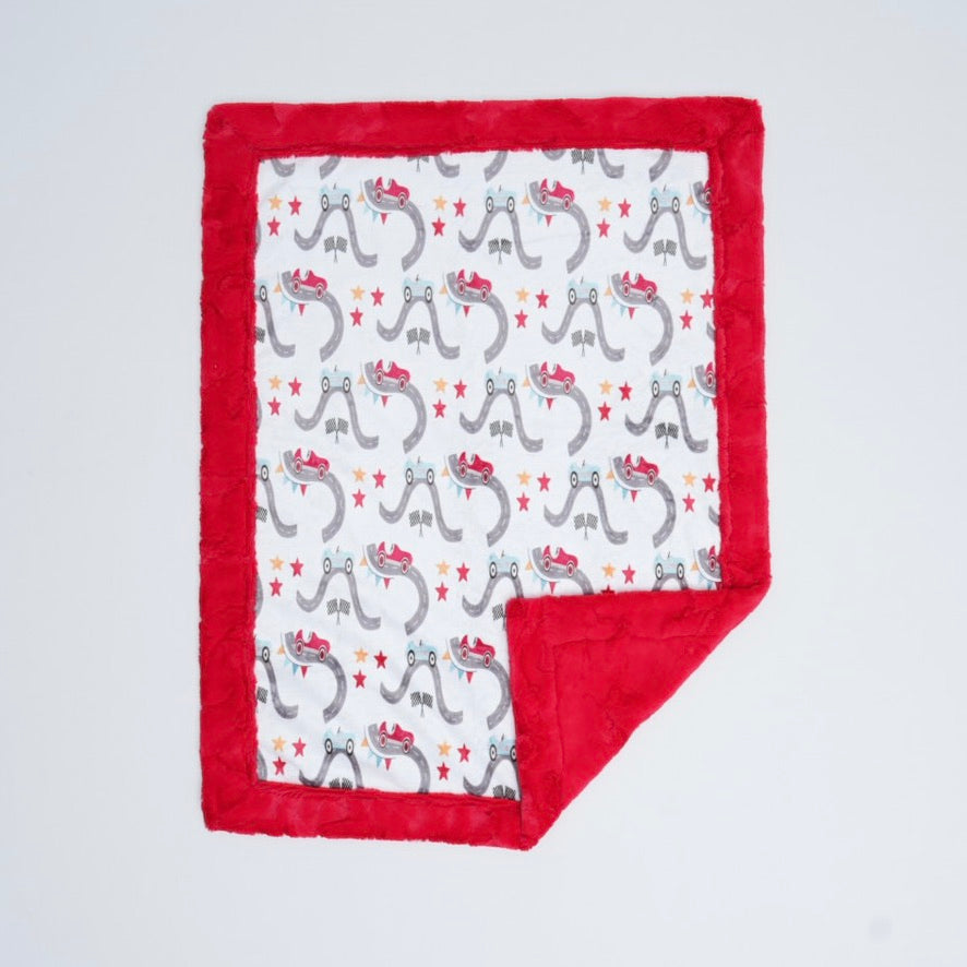 Baby blanket with red border and animal pattern on a light gray background