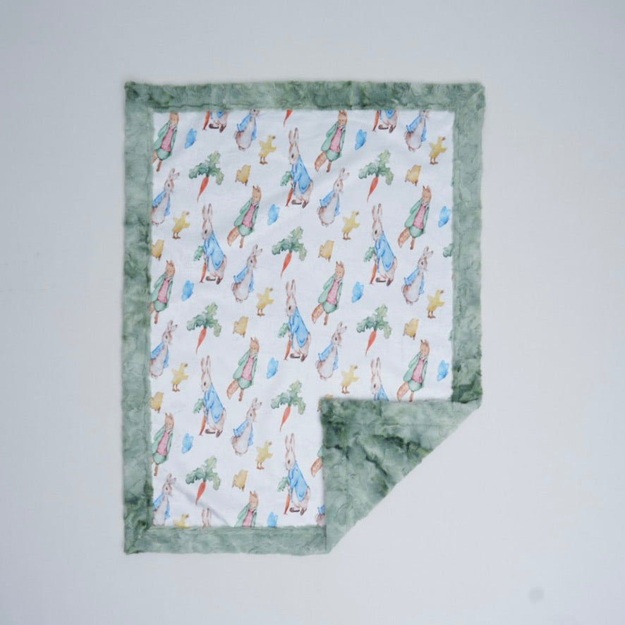 Baby blanket with Peter Rabbit pattern on a white background
