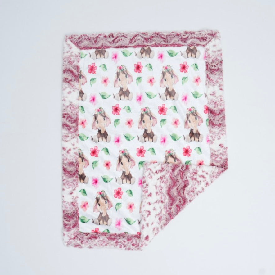 Floral patterned blanket with animal illustrations on a light gray background