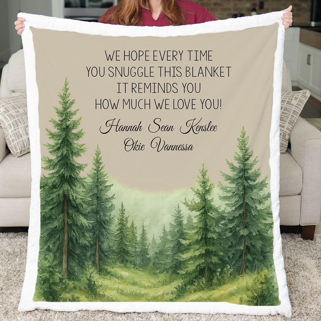 Blanket with forest design and personalized text held by a person in a living room.