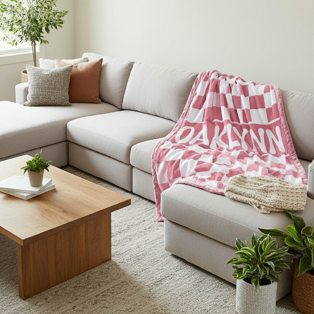 Living room with a beige sectional sofa, wooden coffee table, and pink checkered blanket.