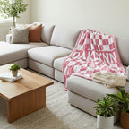 Living room with a beige sectional sofa, wooden coffee table, and pink checkered blanket.