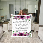 Person holding a floral-themed retirement gift blanket in a living room.