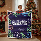 Child holding a 'Game Over' blanket with neon graphics in a festive room with Christmas decorations.