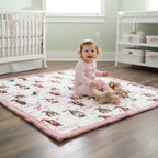 Child playing on a quilt in a nursery with a crib and changing table in the background.