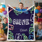 Child holding a 'Game Over' blanket with neon graphics at a birthday party.
