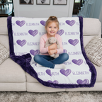 Child sitting on a couch with a personalized blanket featuring purple hearts and the name 'Elizabeth'.