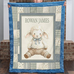 A personalized quilted baby blanket held up by a child, featuring a central illustration of a fluffy white lamb wearing a blue bow and brown pants, surrounded by a blue border and a patchwork design with the name 'ROWAN JAMES' at the top.