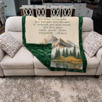 Blanket with scenic design and personalized text on a couch in a living room setting.