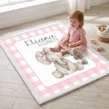 Baby sitting on personalized elephant minky blanket by window with toys
