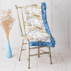 Bear and moon baby blanket with blue minky trim draped over vintage rustic chair