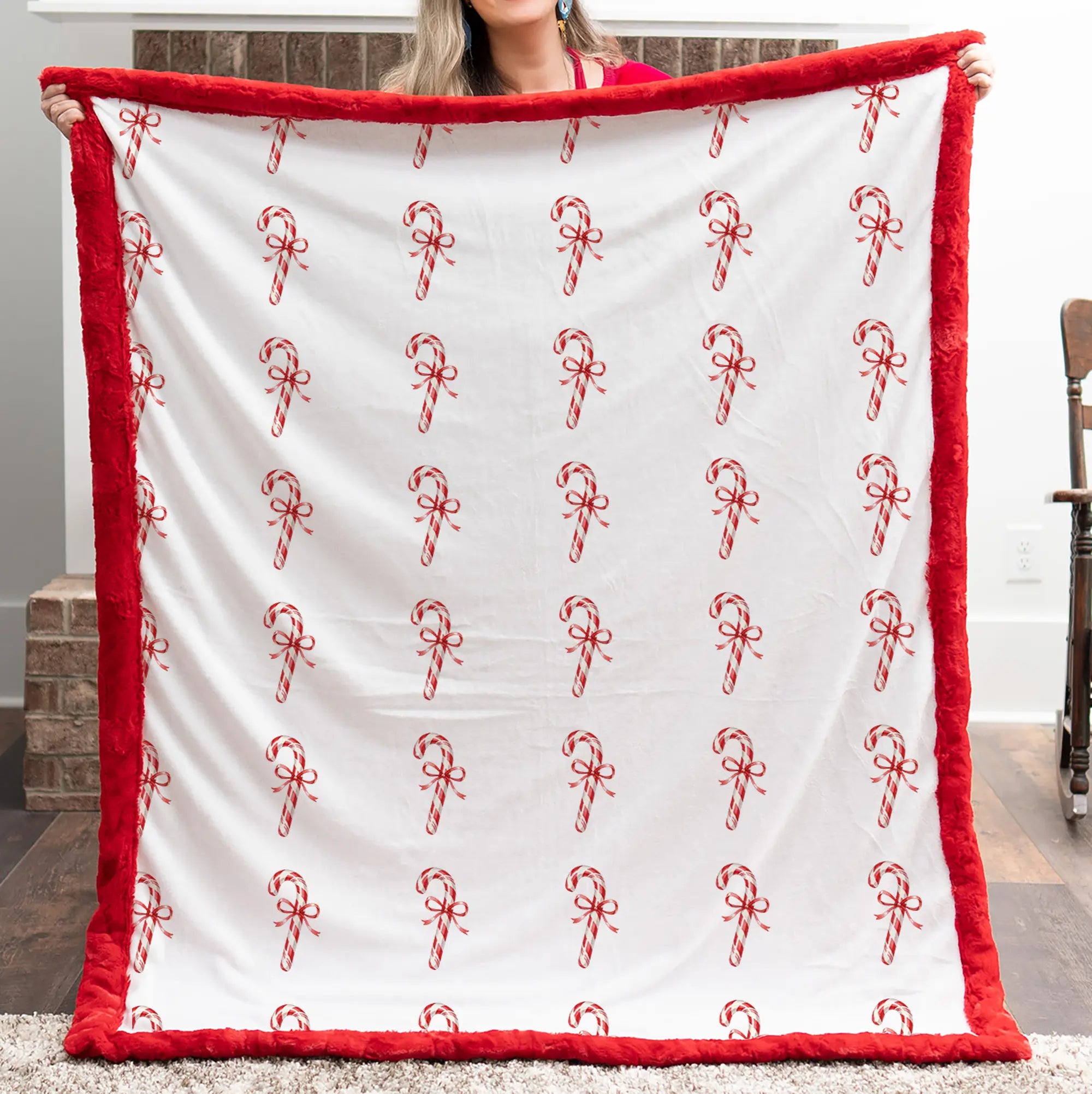 Person holding a white blanket with red candy cane patterns