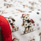 Close-up of a fabric with Christmas-themed dog illustrations and red elements.