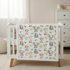 Baby crib with a blanket featuring animal patterns in a nursery setting.