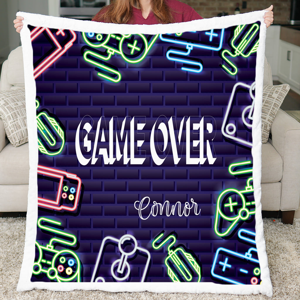 Neon-themed blanket with 'GAME OVER' and 'Connor' text, held by a person in a living room.