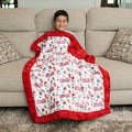 Smiling boy on sofa wrapped in firefighter Luxe Cuddle blanket with fire truck and Dalmatian print