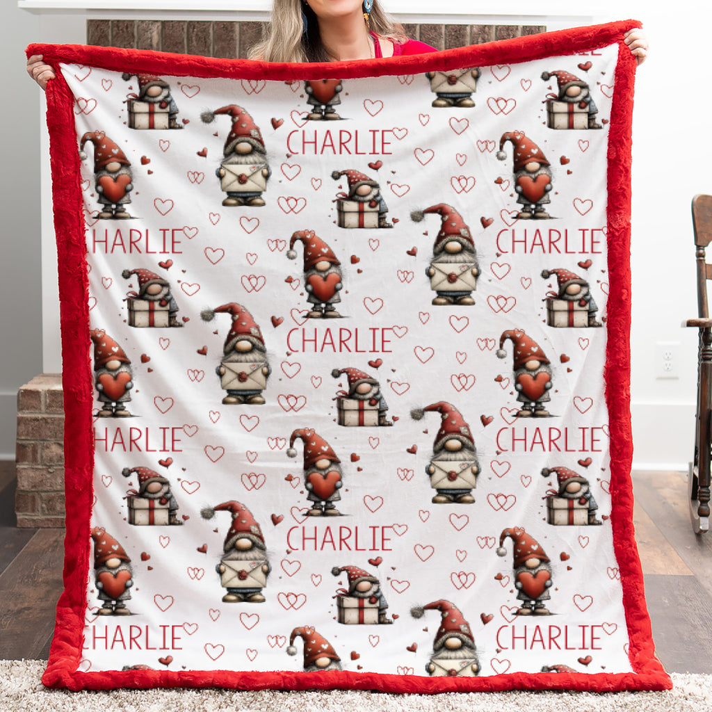Blanket with gnome pattern and 'Charlie' text held by a person outdoors.