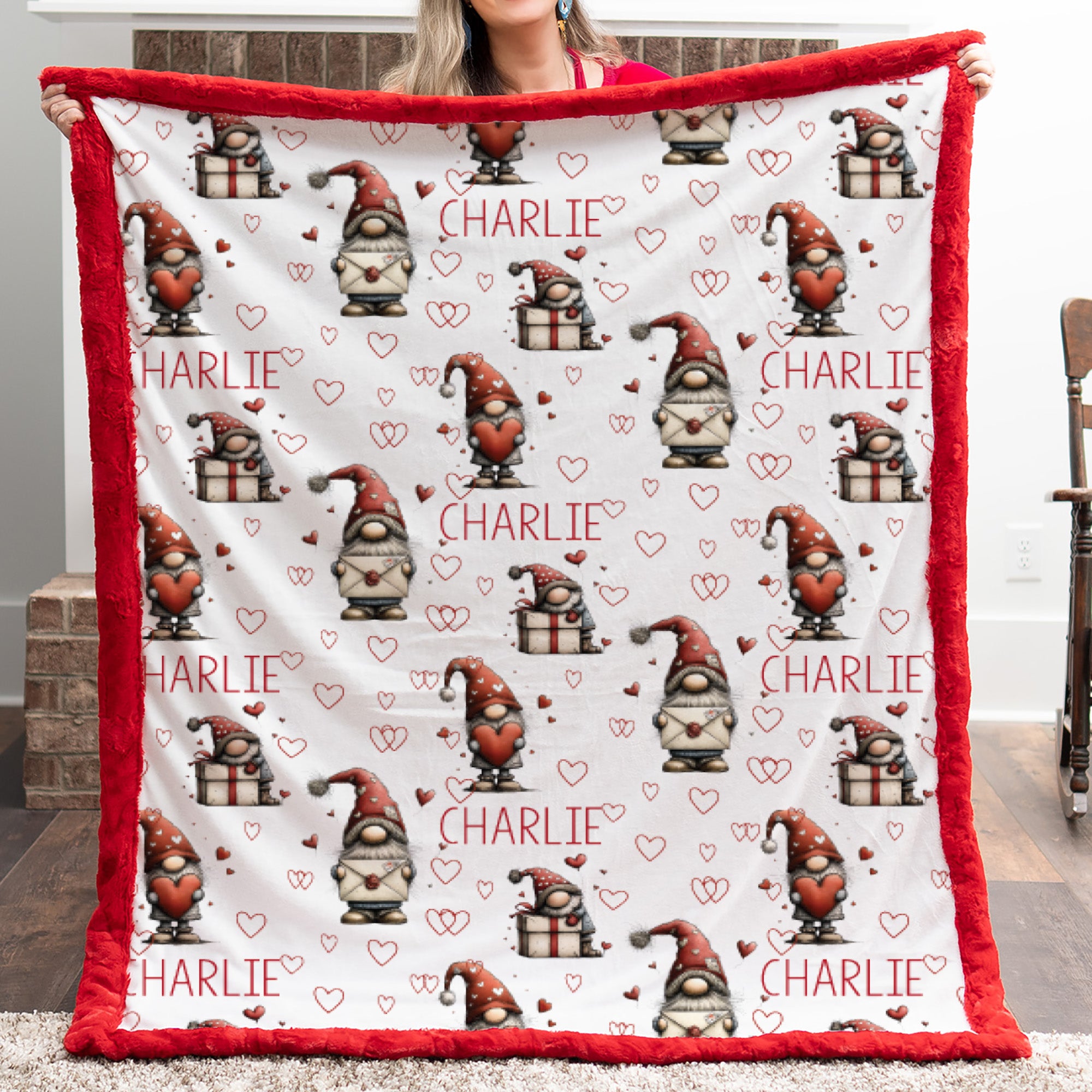Blanket with gnome pattern and 'Charlie' text held by a person outdoors.