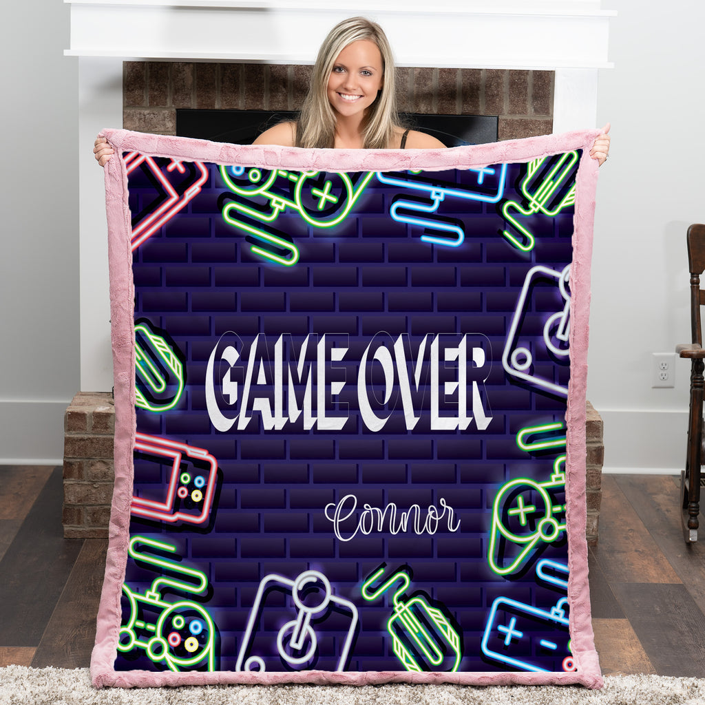 Person holding a blanket with 'Game Over' and neon graphics in a room.