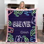 Person holding a blanket with 'Game Over' and neon graphics in a room.