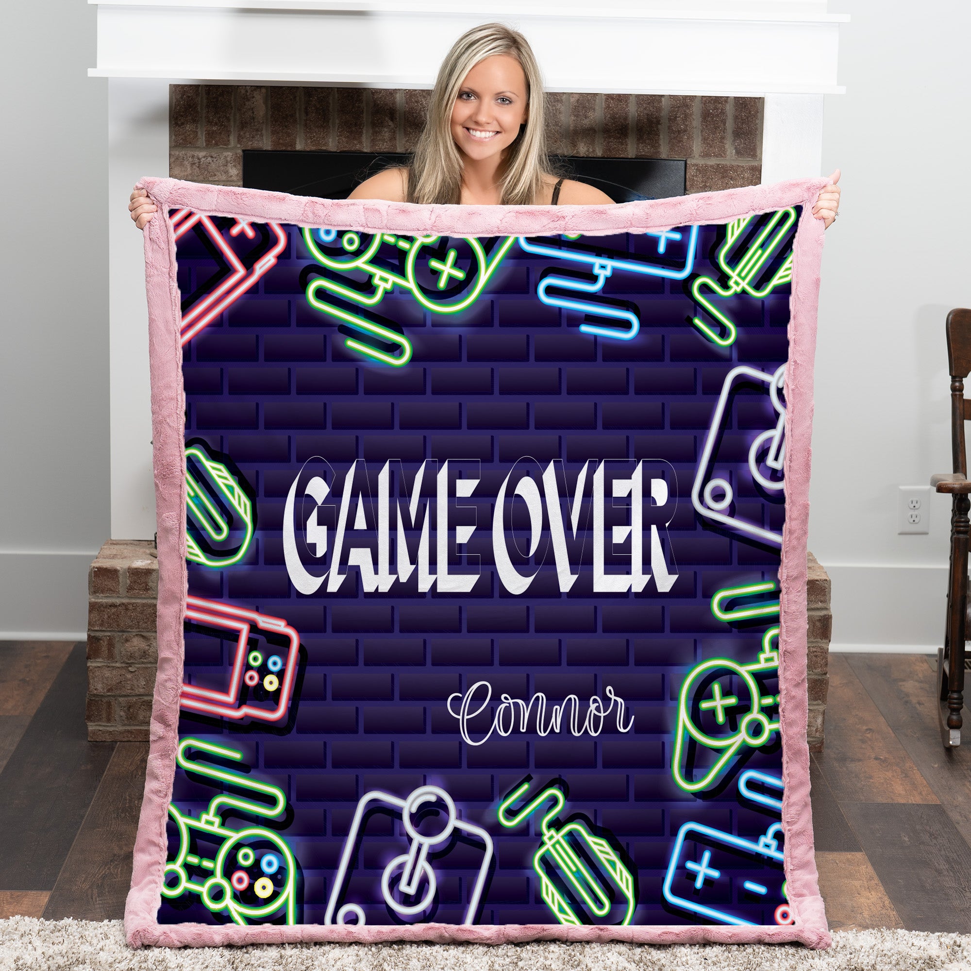 Person holding a blanket with 'Game Over' and neon graphics in a room.
