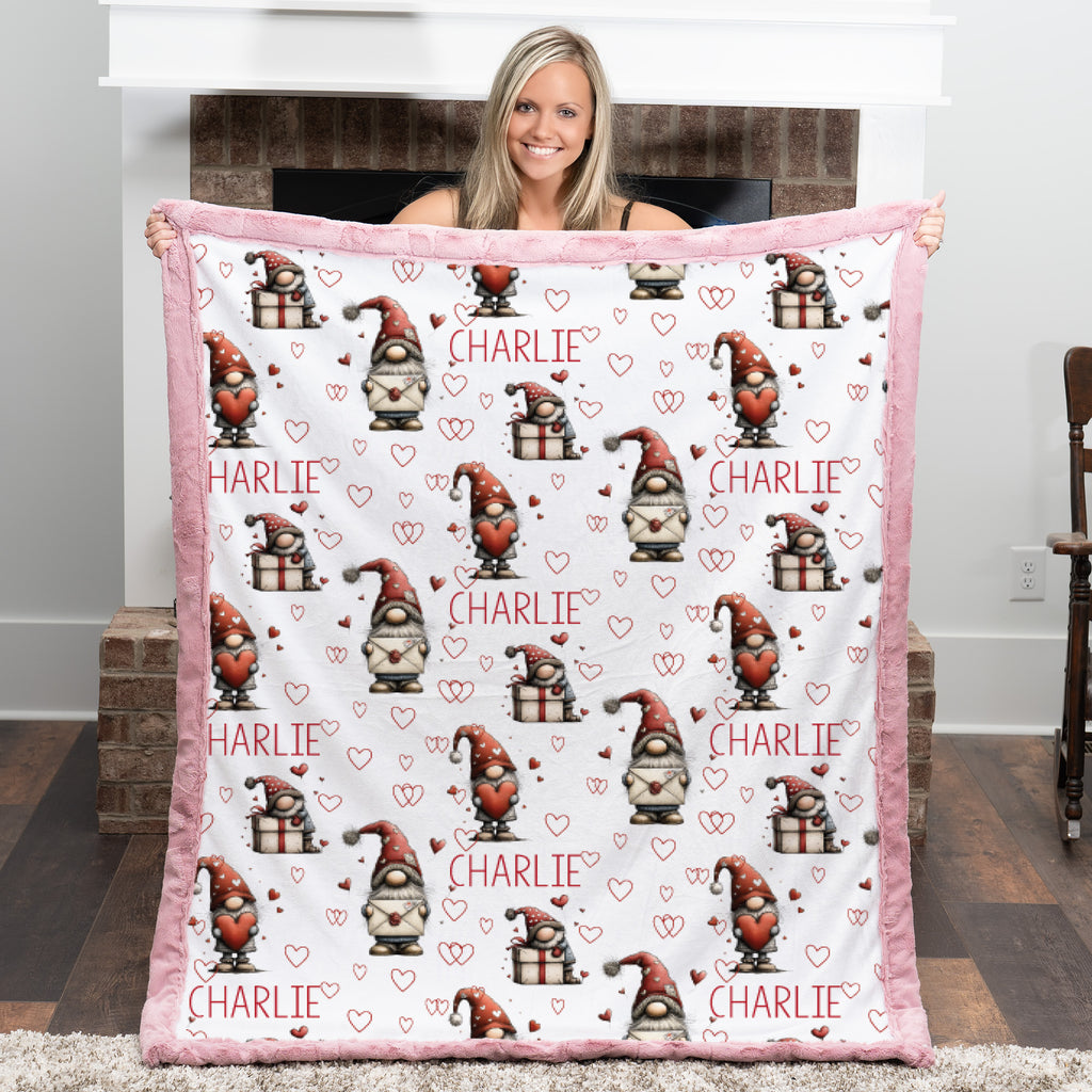 Person holding a blanket with gnome pattern and 'Charlie' text