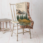The blanket is folded sitting on a. chair.