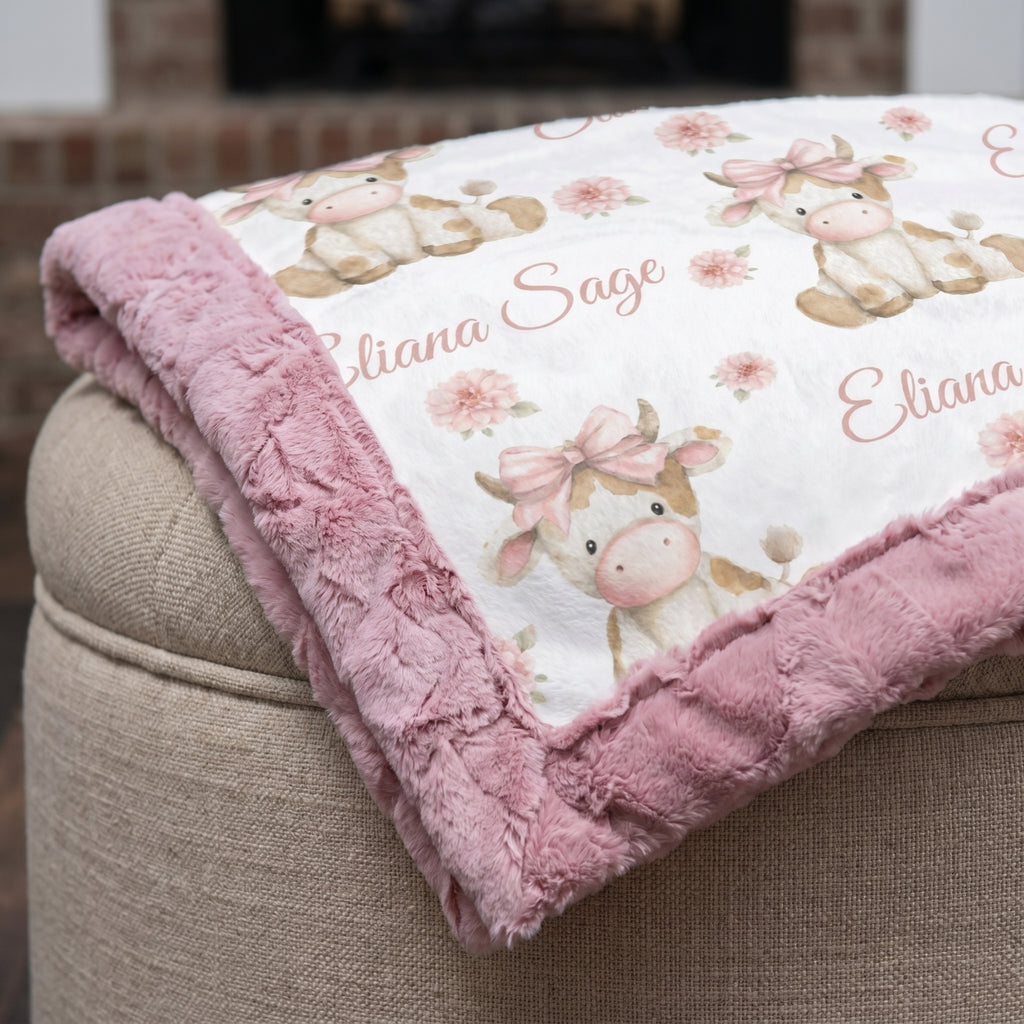 Close-up of pink rosette fur backing on highland cow blanket by fireplace