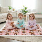 Three children sitting on a checkered blanket in a living room.