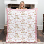 Personalized highland cow minky baby blanket with bright pink fur trim, held up by fireplace