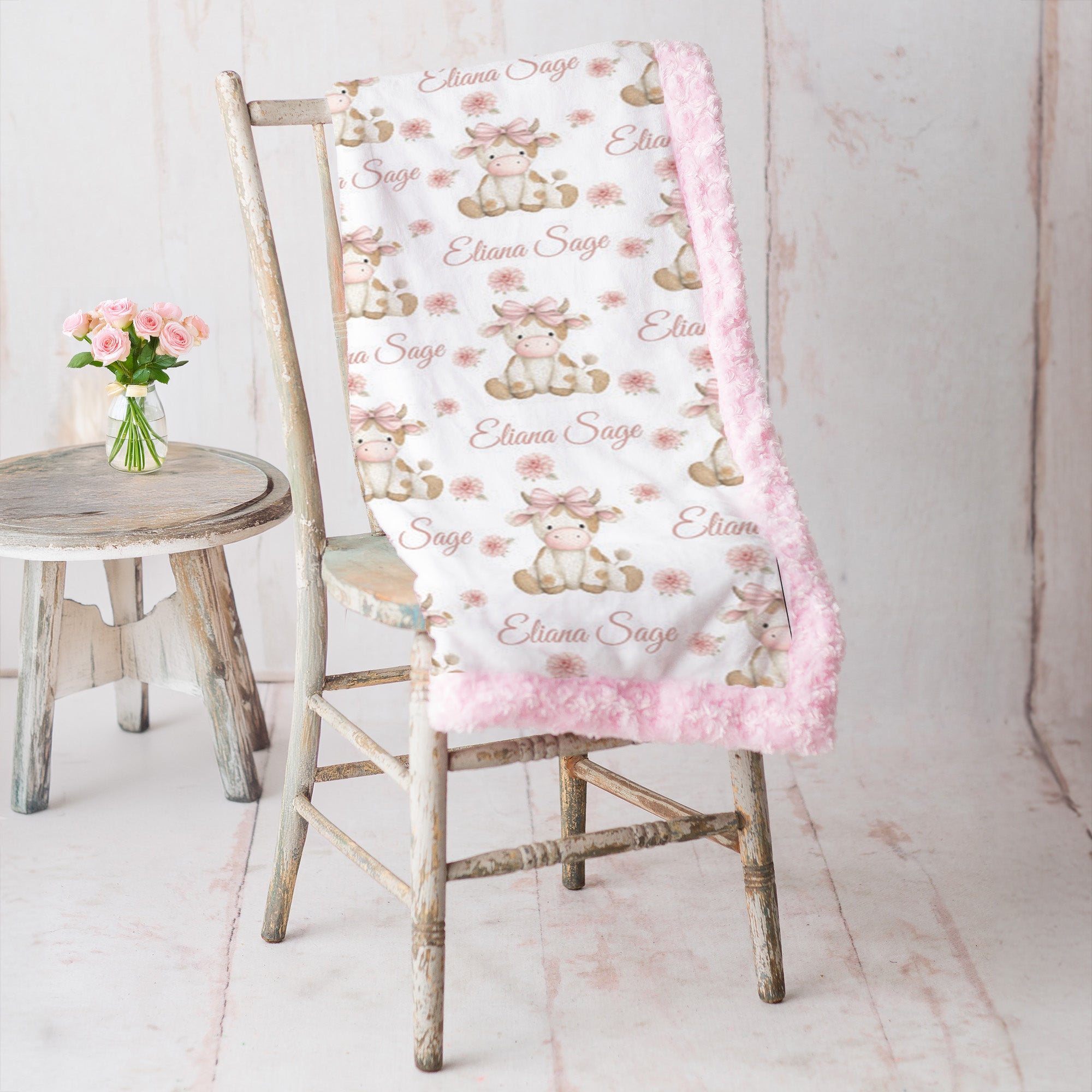 Highland cow minky blanket draped over rustic chair, pink rosette fur backing