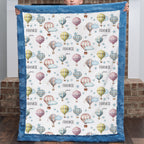 Personalized hot air balloon baby blanket with blue minky border, held up by a child