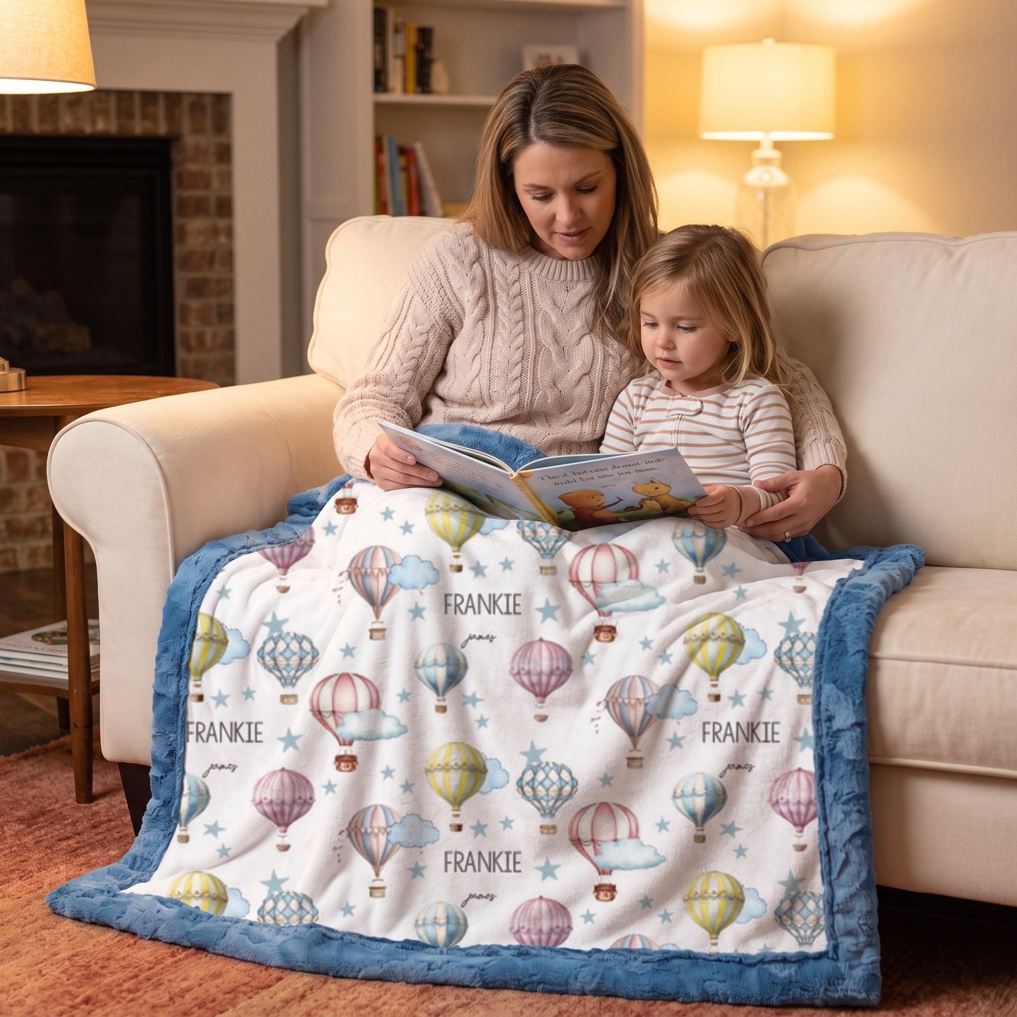 Mom and toddler reading together under a personalized hot air balloon minky baby blanket