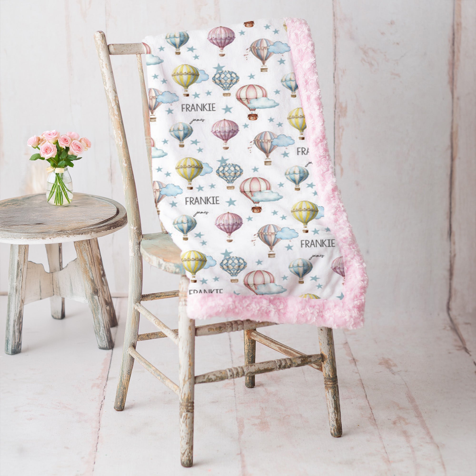 Personalized hot air balloon blanket with pink rosette minky backing on rustic chair