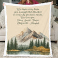 Blanket with mountain and forest design held by a person in a living room.