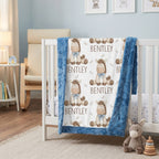 A personalized baby blanket with a blue faux-fur border and a white center printed with cartoon donkeys and the name 'BENTLEY', draped over a white crib in a styled nursery setting.