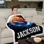 Person sitting on a couch with a personalized blanket featuring a football design and the name 'Jackson'.