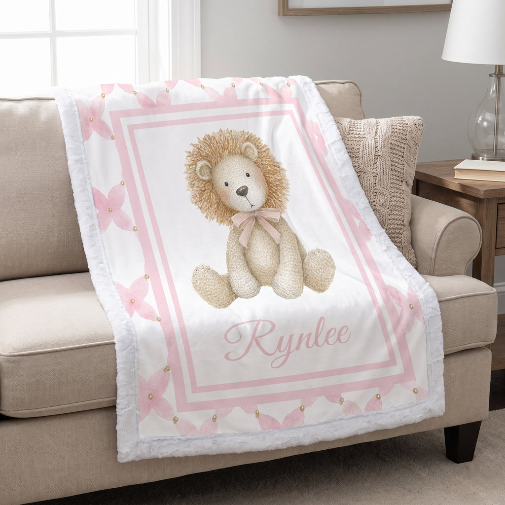 Personalized lion minky baby blanket with white fur trim, draped over cream armchair