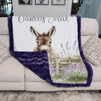 Personalized baby donkey minky blanket with purple trim draped over couch in living room