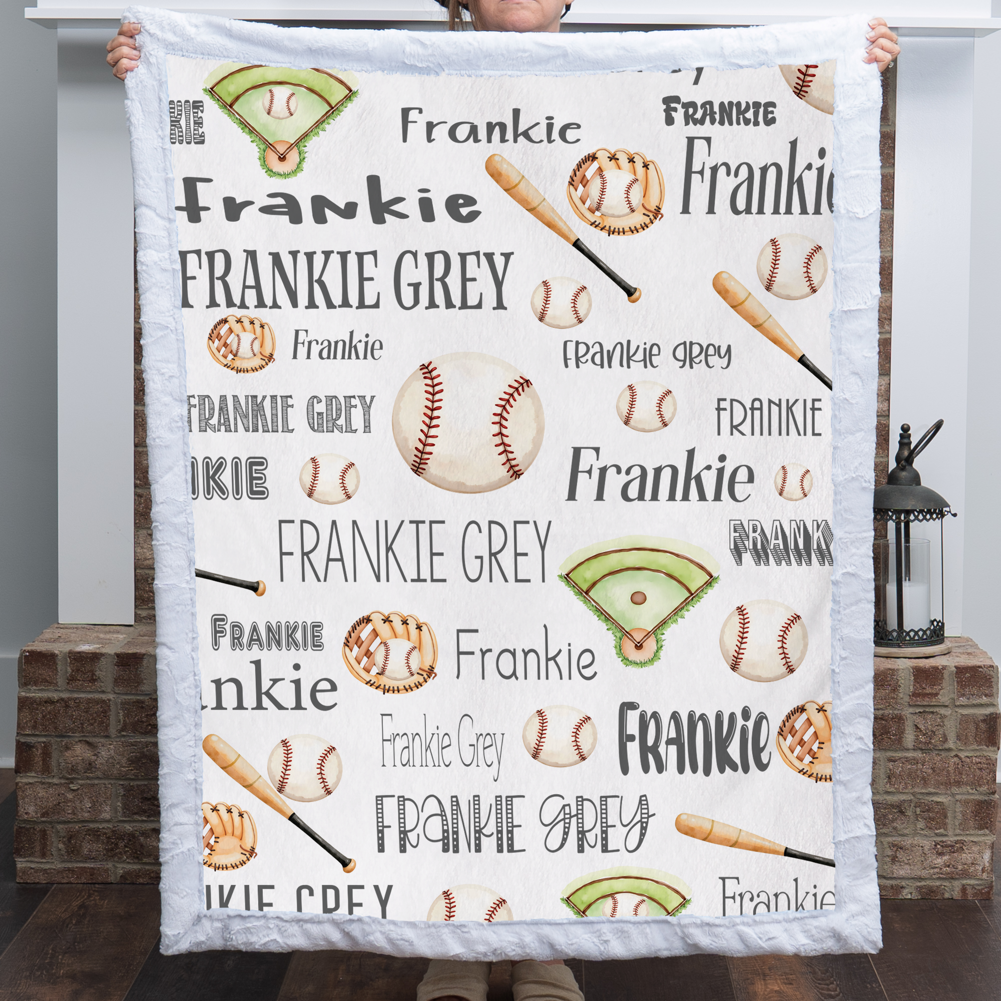 Woman holding personalized baseball blanket with custom name by fireplace, white faux fur trim