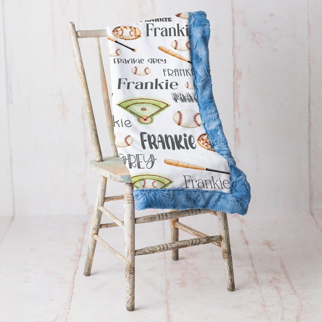 Personalized baseball blanket draped over vintage chair, blue faux fur trim