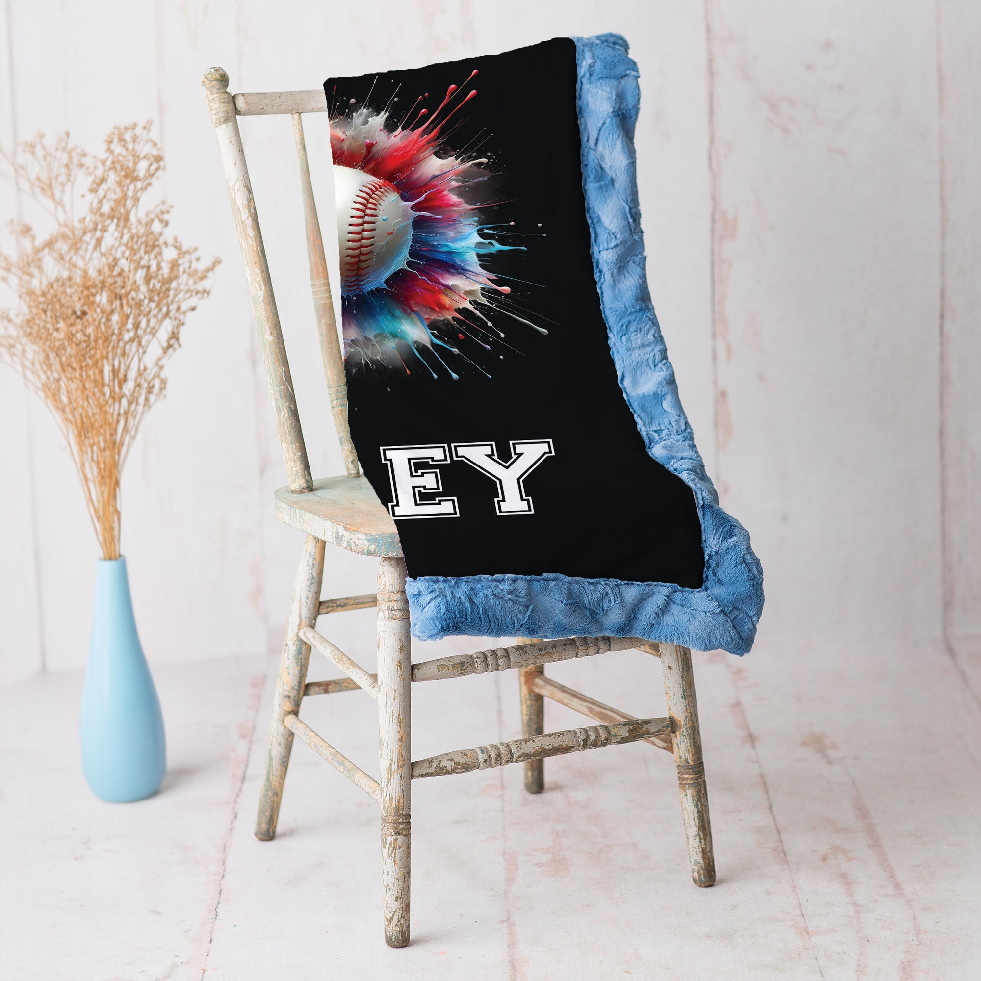 Close-up of personalized baseball minky blanket draped over vintage chair with blue trim